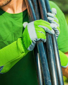 Technician holding irrigation pipes with gloves